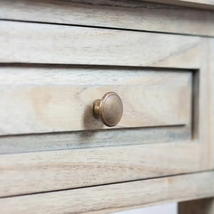 Close-up of brushed metal circular knob on whitewashed wood drawer of Tara Lane end table with horizontal shaker-style paneling detail