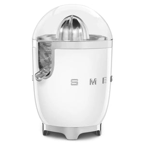 White Smeg 50s retro style electric citrus juicer with stainless steel dome top and lever, clear acrylic body showing internal mechanism, compact cylindrical design with chrome accents and stabilizing feet