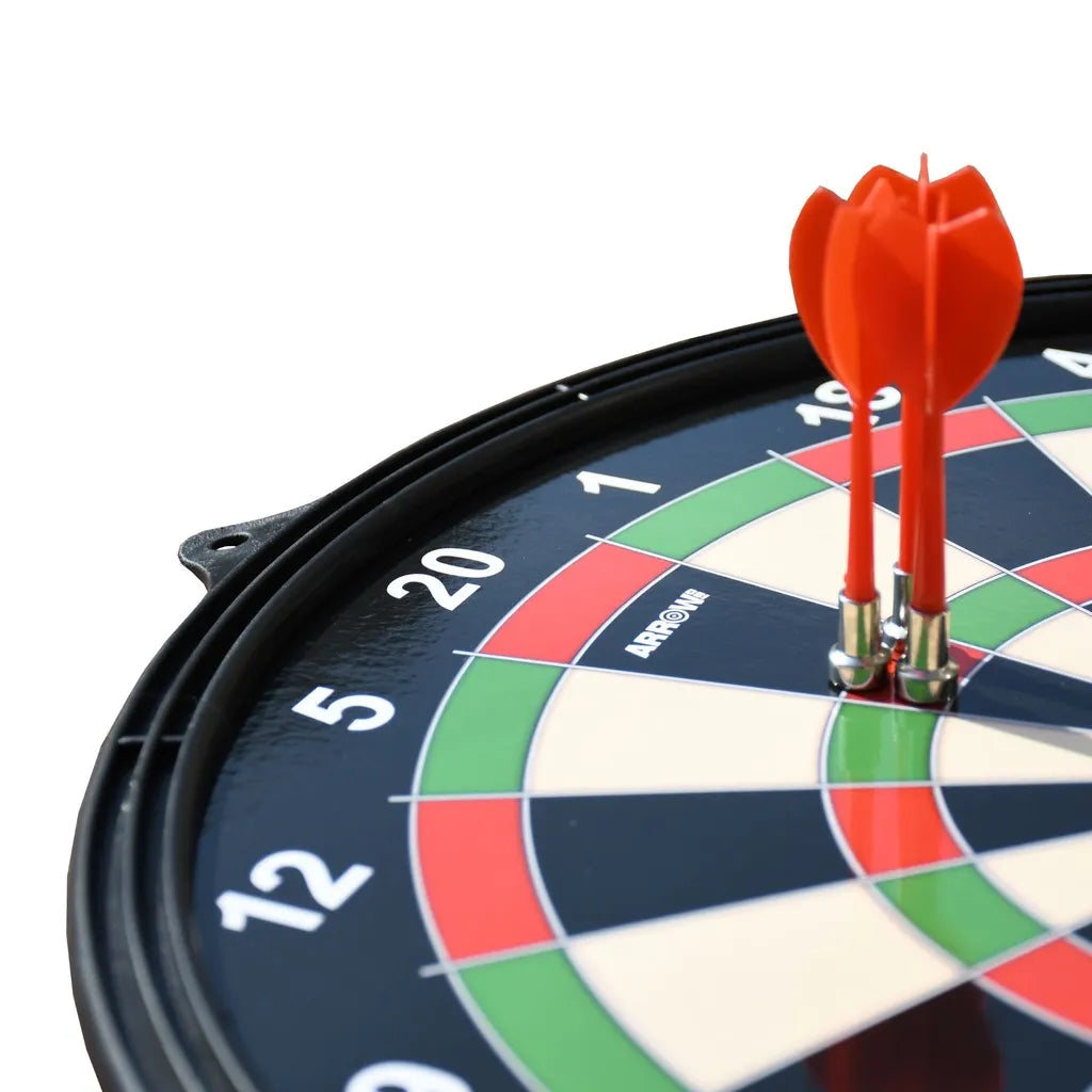 Close-up of a magnetic dartboard with red darts lodged in the center, featuring a black frame, colored segments in navy blue, red, green and cream, and numbered scoring rings from 2 to 20