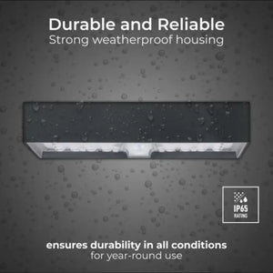Luceco solar brick light slate grey with weatherproof housing and IP65 rating, displaying water droplets on grey background to demonstrate durability