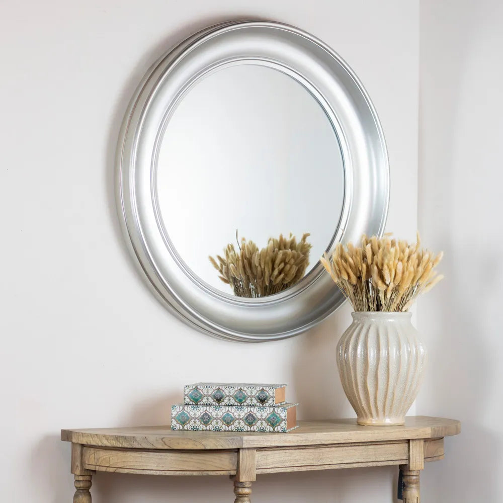 Tara Lane Lyla Round Mirror 90cm in champagne finish mounted on white wall above wooden console table styled with cream ceramic vase containing dried pampas grass and decorative patterned boxes