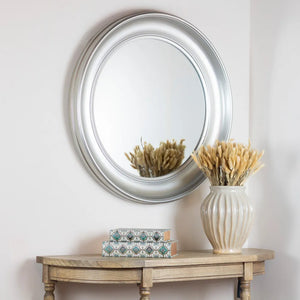 Tara Lane Lyla Round Mirror 90cm in champagne finish mounted on white wall above wooden console table styled with cream ceramic vase containing dried pampas grass and decorative patterned boxes