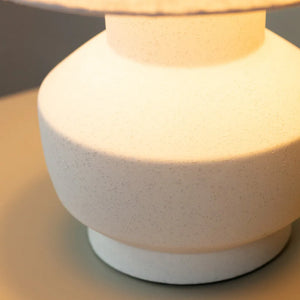 Tara Lane Chloe white ceramic bedside lamp with textured speckled finish, cylindrical dome shade, glowing warm light, 36cm height