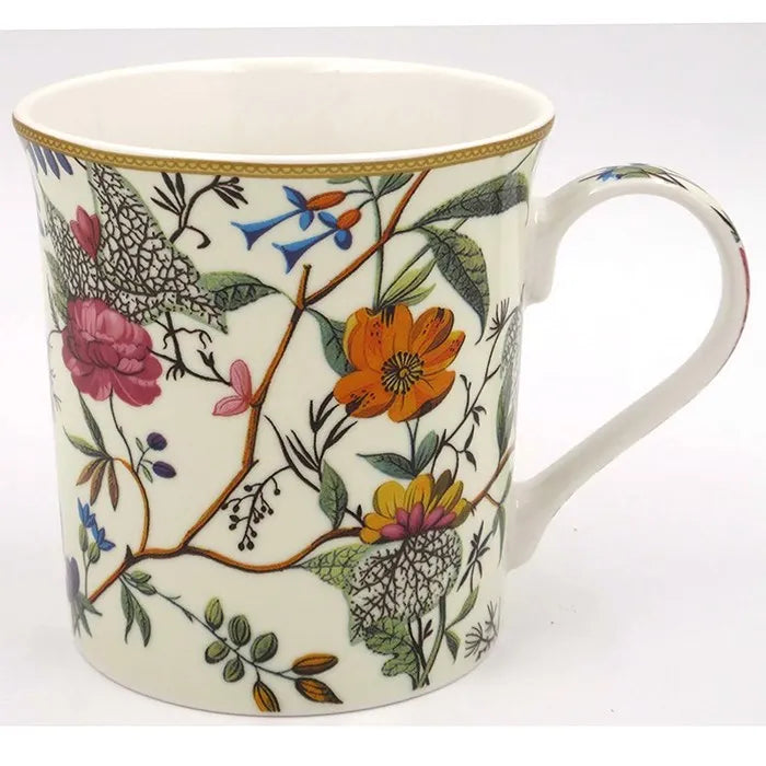 Ceramic mug featuring William Kilburn botanical design with colorful hand-painted flowers including pink peonies and orange blooms, delicate blue birds, green foliage and branches on cream background, gold-trimmed rim, white interior, porcelain with curved handle