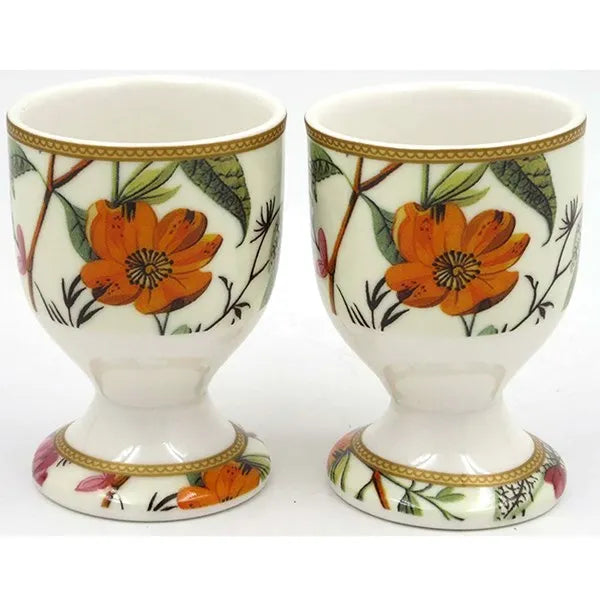 Pair of cream porcelain eggcups with gold trim featuring William Kilburn botanical design with orange flowers, green leaves and branches on pedestal base