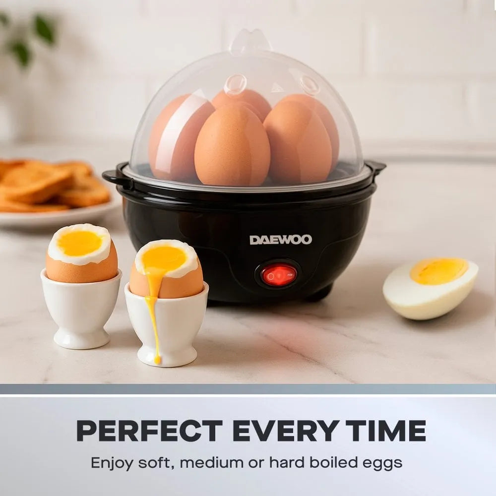 Daewoo black electric egg cooker with clear dome lid containing brown eggs, displaying three soft-boiled eggs in white ceramic cups with runny yolks, one hard-boiled egg half, red power button, alongside plate with pastries on marble countertop