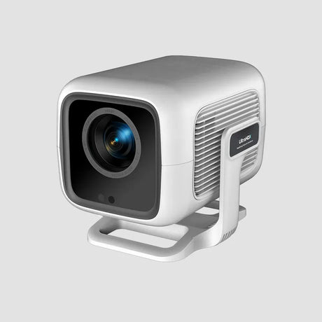 White compact portable projector with rounded design, featuring a black lens on the front, ventilation grille on the side, and a stand base, displayed against a light gray background