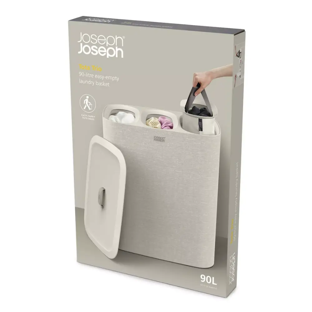 Joseph Joseph Tota Trio 90-litre easy-empty laundry basket in ecru with removable dividers and carry handles, shown with lid open displaying compartments for sorted laundry
