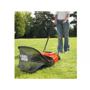 Black & Decker GD300 electric lawnraker with red and black body being used on grass, showing collection bag and operating handle with person in jeans standing behind device in garden setting