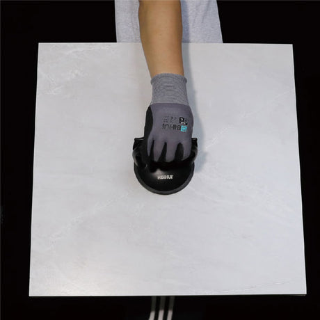 Hand wearing gray work glove with black suction cup tool demonstrating Bihui single head aluminum alloy suction cup on white surface