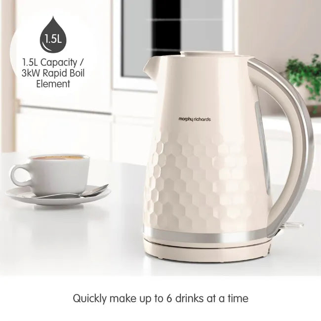 Morphy Richards Hive cream electric kettle with 1.5L capacity and 3kW rapid boil element, featuring textured honeycomb design, shown alongside white teacup with specifications stating it quickly makes up to 6 drinks at a time