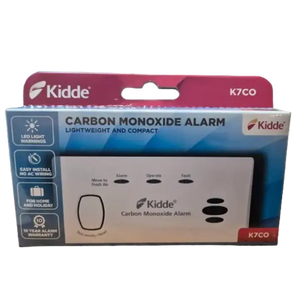 Kidde K7CO carbon monoxide alarm in packaging, white rectangular device with three black button controls labeled Alarm, Operate and Fault, displayed in burgundy and blue retail box with LED light warnings and 10-year warranty information