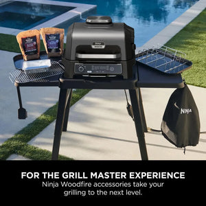 Ninja woodfire grill with accessories on a patio near a pool