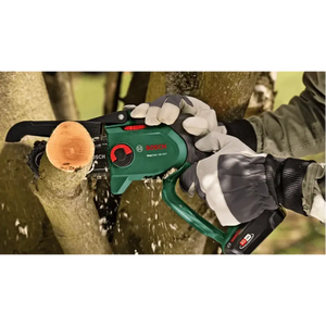 Bosch EasyChain 18V cordless chainsaw in green and black being held by gloved hands cutting through a wooden log, showing the chainsaw bar and chain in action with wood shavings flying