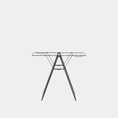 Black metal winged clothes airer with tripod legs and horizontal drying rails, front view on grey background