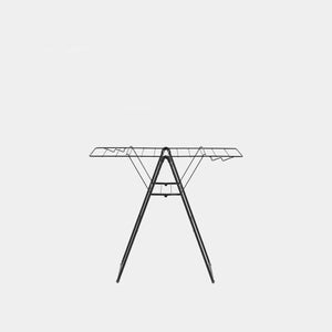 Black metal winged clothes airer with tripod legs and horizontal drying rails, front view on grey background