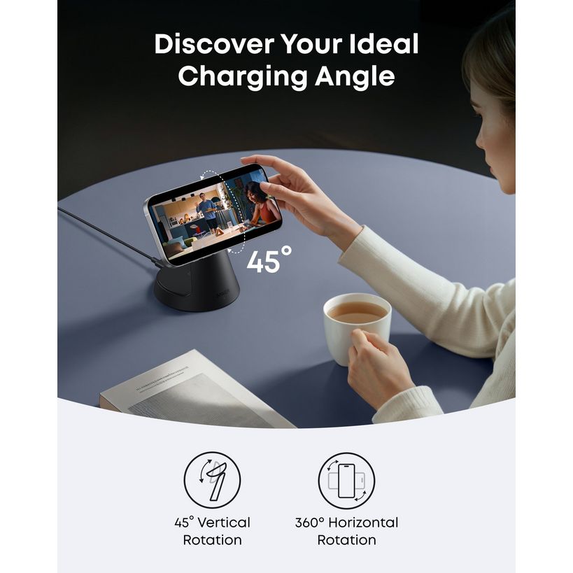 Woman holding smartphone on black cone-shaped wireless charging stand at 45-degree angle on gray table with coffee cup and magazine, demonstrating adjustable vertical and horizontal rotation features of Anker MagGo 3-in-1 charging dock