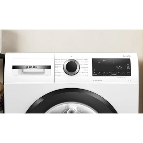Bosch Series 6 white front-load washing machine with 9kg capacity, 1400 spin speed, featuring a large black drum door, central dial control, digital display panel, and Iron Assist function