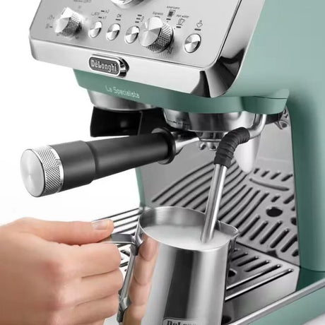 DeLonghi La Specialista Arte manual bean to cup espresso machine in green and stainless steel with steam wand and portafilter, showing hand-operated milk frothing demonstration