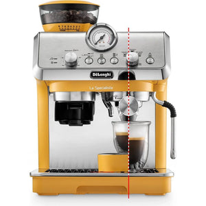 DeLonghi La Specialista Arte manual bean to cup espresso machine in yellow and stainless steel with integrated grinder, pressure gauge, and glass cup showing espresso extraction