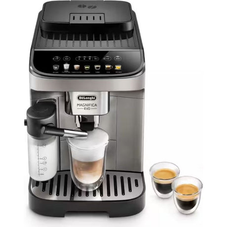DeLonghi Magnifica Evo automatic bean to cup coffee machine in titanium black with stainless steel accents, featuring a touch display panel, milk frother on the left side, and two double-wall espresso cups with freshly brewed coffee displayed to the right