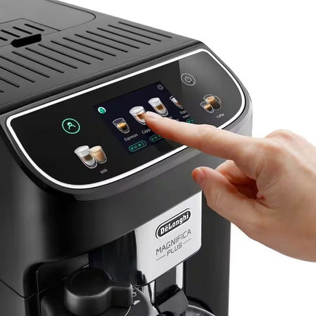 Hand selecting espresso on DeLonghi Magnifica Plus automatic coffee machine with black finish and touchscreen display showing beverage options including espresso, cappuccino, latte and milk drinks