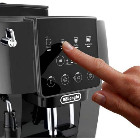 DeLonghi Magnifica Start automatic coffee machine in grey and black with touch screen display showing drink options including espresso, coffee and americano, with a hand pressing the control panel
