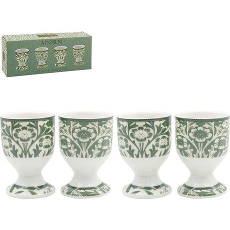 Set of four white ceramic eggcups with green floral acorn pattern design, pedestal base style, shown with original packaging box in green with product illustrations