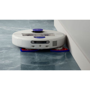 Dyson R2 Nurovi white and blue robot vacuum cleaner with red and blue cleaning pads on grey tiled floor next to white baseboard
