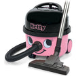 Hetty HET200 pink and black compact vacuum cleaner with smiling face design, featuring black top lid, attached hose, and floor brush head on white background