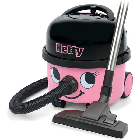 Hetty HET200 pink and black compact vacuum cleaner with smiling face design, featuring black top lid, attached hose, and floor brush head on white background