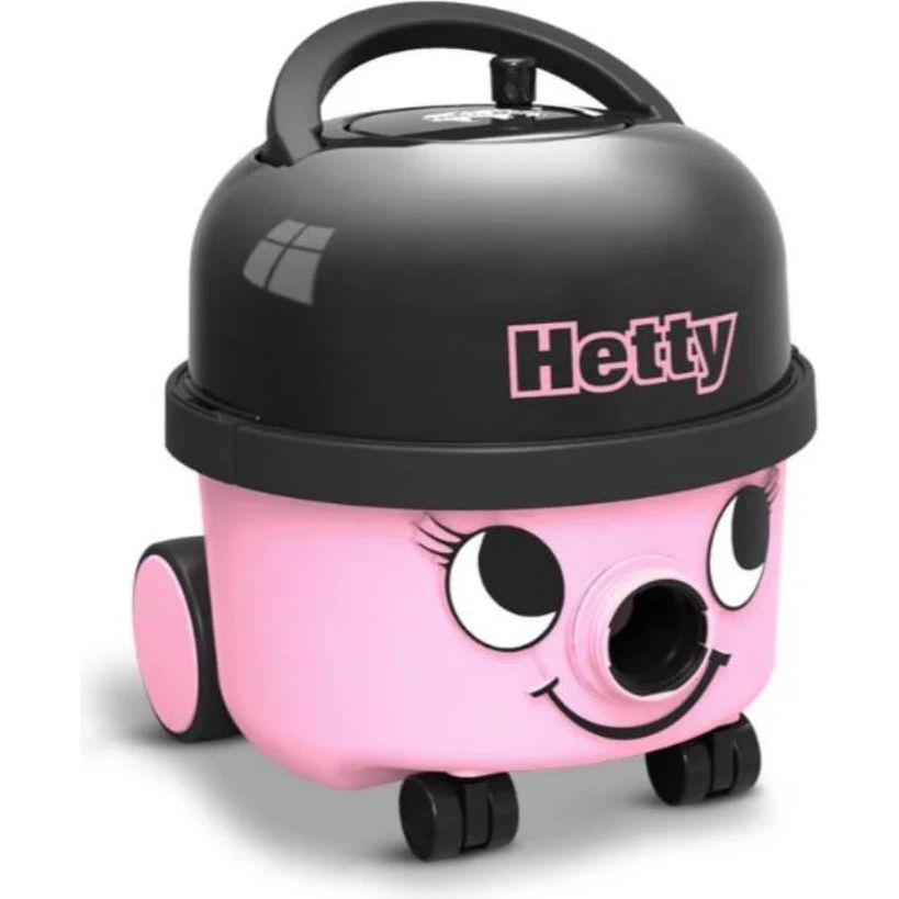 Pink and black Hetty vacuum cleaner with smiling face, large cartoon eyes, black handle on top, wheels at base, and Hetty branding on black dome lid