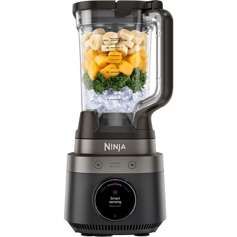 Ninja CrushBOSS 1200W intelligent blender with onyx black base and stainless steel accents, featuring a clear glass pitcher filled with layered ingredients including ice, green kale, yellow mango, cashews and banana, displaying smart sensing technology display screen