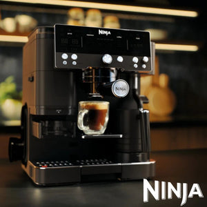 Ninja Luxe Café Premier Series black coffee machine with digital display and control panel, dispensing dark espresso into a glass cup, showcasing modern stainless steel and black design with professional features for cold brew and espresso preparation
