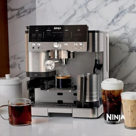 Ninja Luxe Café Premier Series stainless steel and black coffee machine on marble countertop displaying espresso, cold brew and iced coffee beverages in glass cups and mugs