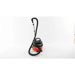 Numatic Henry red and black compact wet and dry vacuum cleaner with hose and handle on white background
