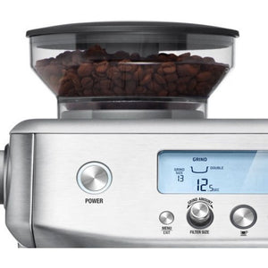 Sage Barista Pro espresso machine in brushed stainless steel with integrated conical burr grinder, digital display showing grind settings, and bean hopper filled with dark coffee beans