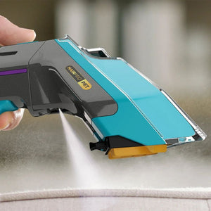 Shark CarpetXpert HairPro Pet deep carpet cleaner in turquoise and black with yellow accents, held in hand above carpet showing the StainStriker feature and spray function