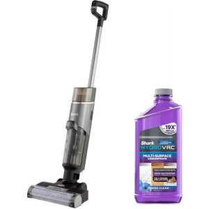 Shark HydroVac cordless vacuum cleaner in silver and black with upright handle alongside purple Shark HydroVac multi-surface concentrate cleaning solution bottle