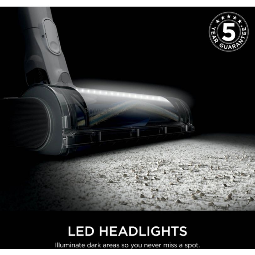 Shark PowerPro cordless stick vacuum with LED headlights illuminating floor surface, featuring anti-hair wrap technology and floor detect, shown with 5-year guarantee badge