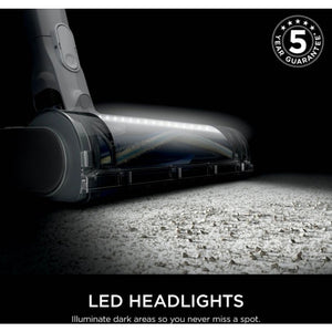 Shark PowerPro cordless stick vacuum with LED headlights illuminating floor surface, featuring anti-hair wrap technology and floor detect, shown with 5-year guarantee badge