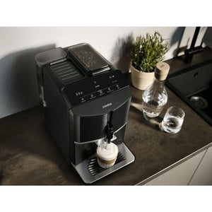 Siemens EQ300 black fully automatic bean to cup coffee machine dispensing cappuccino on kitchen counter with water glasses and potted plants