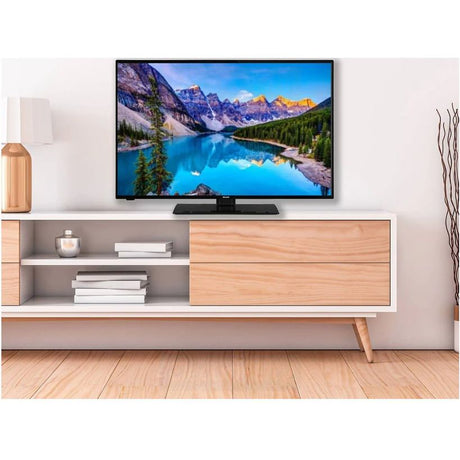 Walker 40 inch QLED Tivo 2K Smart TV mounted on white modern TV stand with natural wood drawers and shelving, displaying mountain lake landscape, wooden flooring and minimalist interior design