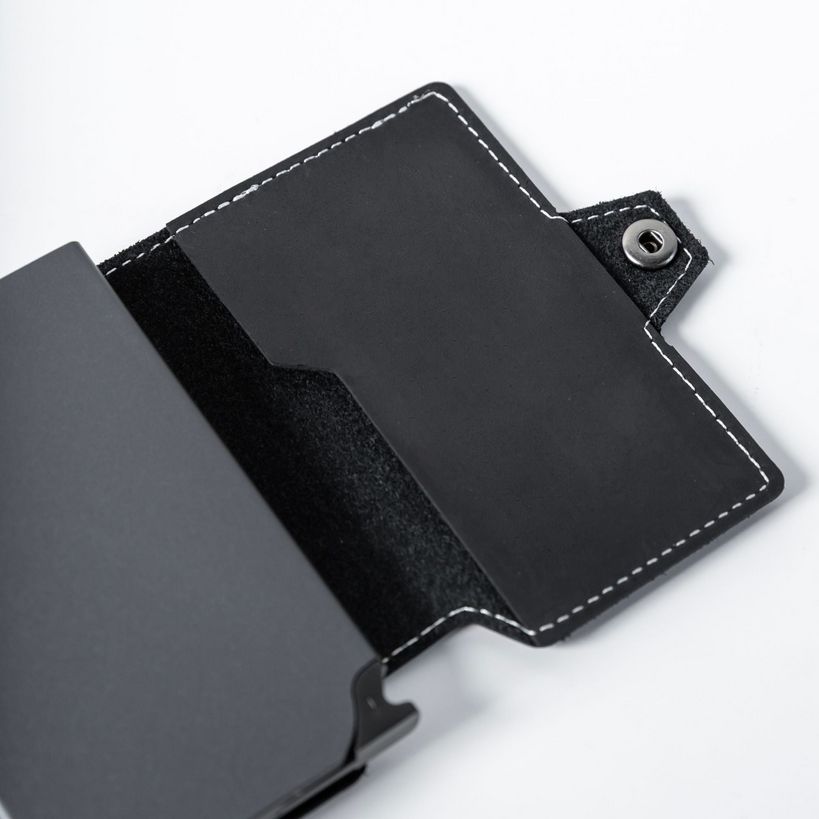 Wallet Junkie Pro Slim midnight black leather cardholder with white stitching and snap closure, holding multiple cards, displayed open on white background