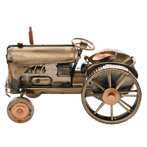 Vintage bronze and copper metal tractor ornament with detailed steering wheel and mechanical features, isolated on white background