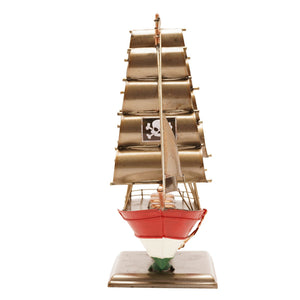 Brass clipper boat ornament with red, white and green painted hull on metal stand, featuring tan canvas sails and small window detail