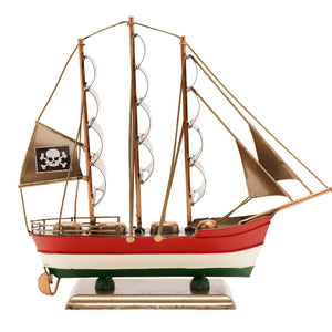 Decorative wooden clipper ship model with red white and green hull, three masts with tan canvas sails, skull and crossbones pirate flag, brass fittings and green wooden stand base