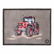 Hug Rug doormat featuring a red farmyard tractor with large black treaded wheels on a grey background, bordered by dark charcoal edging, 65cm x 85cm
