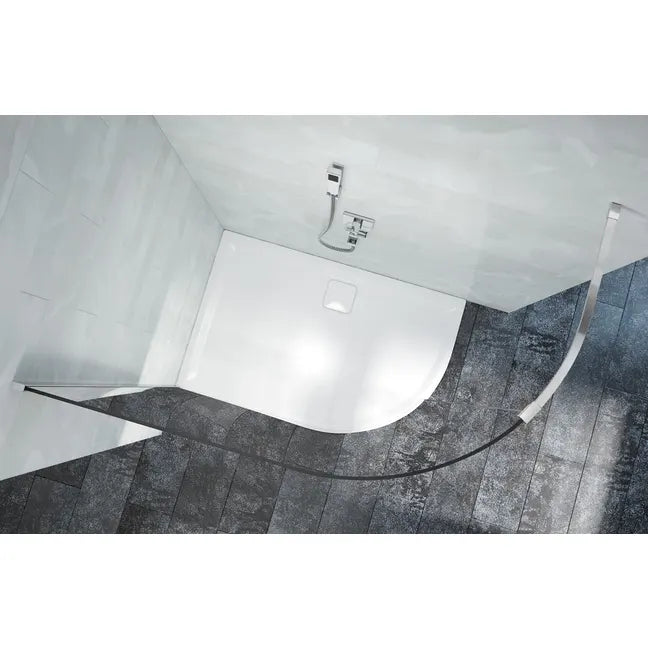 Modern white curved shower tray with chrome faucet mounted on grey tile bathroom floor and white walls