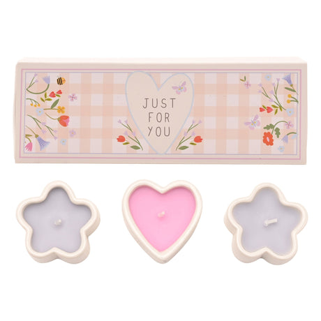 Set of 3 mini scented candles in cream-colored ceramic holders shaped as a pink heart and two purple flowers, displayed with a decorative "Just For You" gift box featuring floral patterns on a pink checkered background